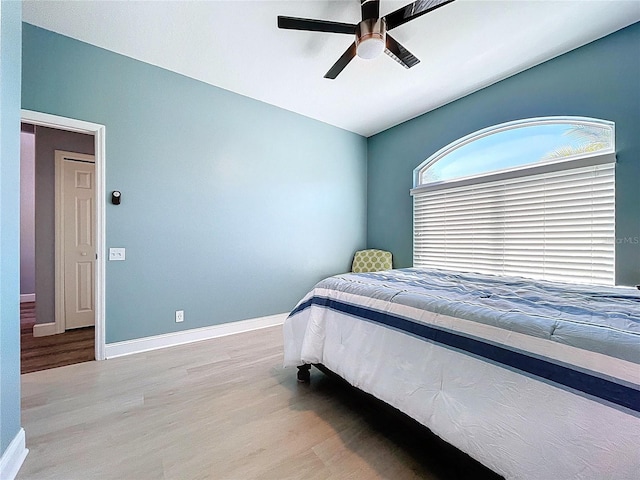 bedroom featuring a ceiling fan, baseboards, and wood finished floors