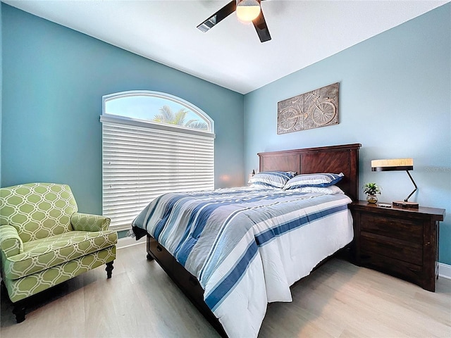 bedroom featuring wood finished floors, baseboards, and ceiling fan