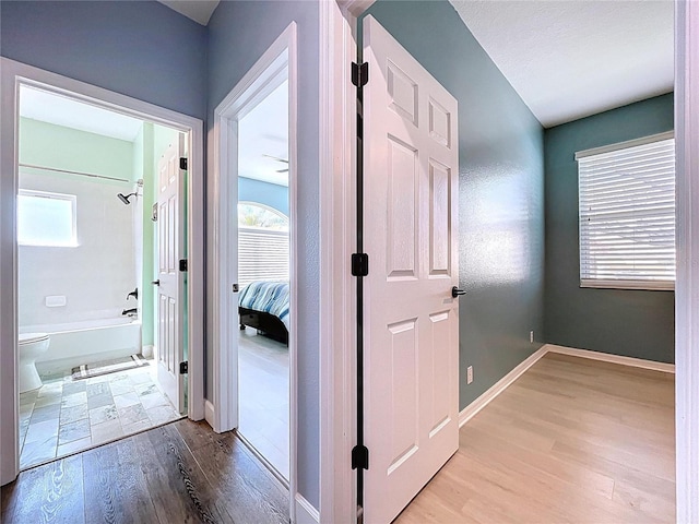 corridor with baseboards and wood finished floors