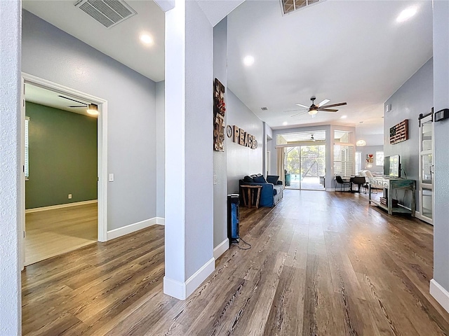 hall with recessed lighting, visible vents, baseboards, and wood finished floors