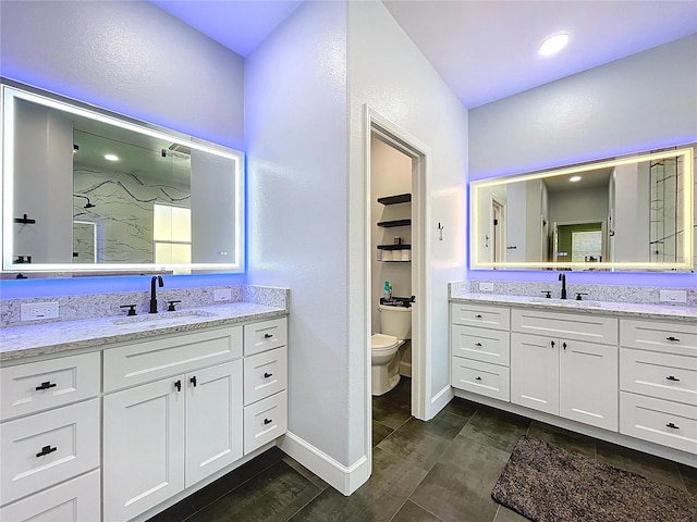 bathroom featuring a sink, toilet, walk in shower, and two vanities