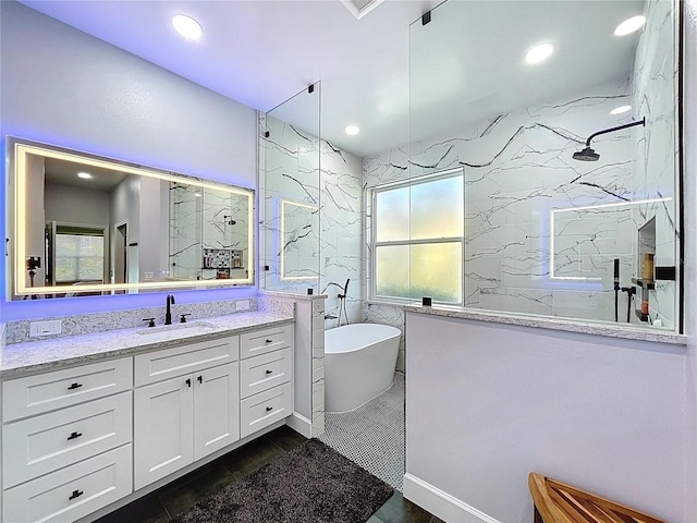 full bath featuring a freestanding tub, a marble finish shower, recessed lighting, and vanity