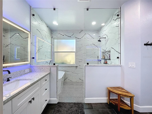 bathroom featuring a marble finish shower, a freestanding bath, and vanity