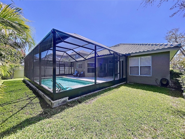 rear view of house featuring a tile roof, a yard, a lanai, and stucco siding