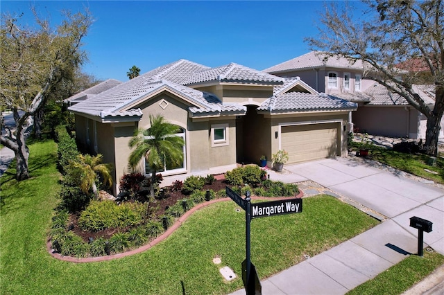 view of front of property featuring a front lawn, a tiled roof, stucco siding, a garage, and driveway