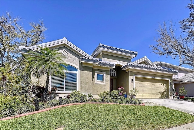 view of front of property featuring driveway, stucco siding, a front lawn, a garage, and a tile roof