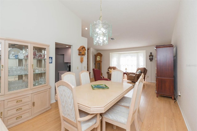 dining space with a notable chandelier, baseboards, light wood-type flooring, and visible vents