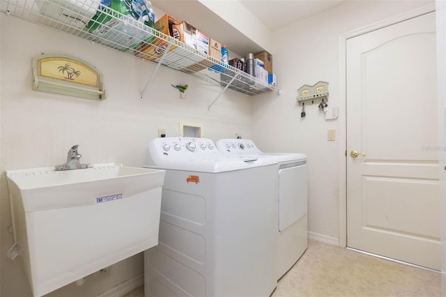 laundry room featuring light carpet, independent washer and dryer, a sink, baseboards, and laundry area