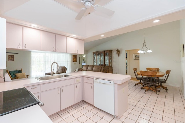 kitchen with light countertops, vaulted ceiling, a peninsula, white dishwasher, and a sink