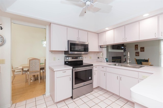 kitchen with backsplash, light countertops, light tile patterned floors, stainless steel appliances, and a sink