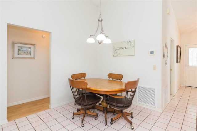 dining room with a notable chandelier, light tile patterned floors, baseboards, and visible vents