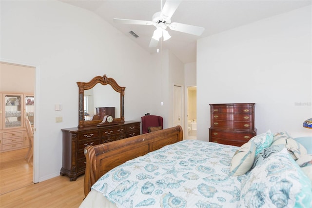 bedroom with visible vents, ceiling fan, light wood-style flooring, ensuite bathroom, and high vaulted ceiling