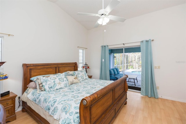 bedroom featuring light wood-type flooring, high vaulted ceiling, a ceiling fan, baseboards, and access to exterior