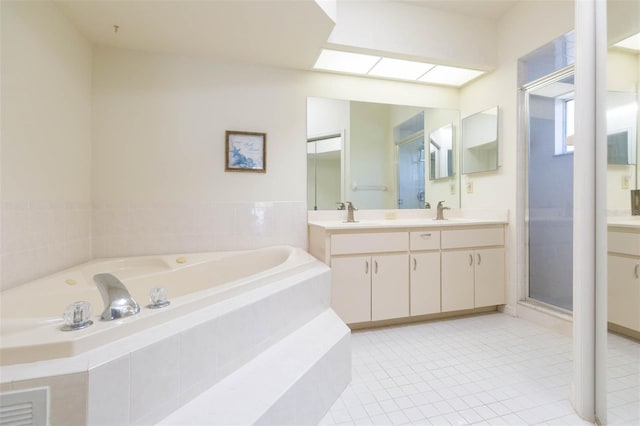 bathroom with a skylight, a garden tub, a stall shower, and vanity