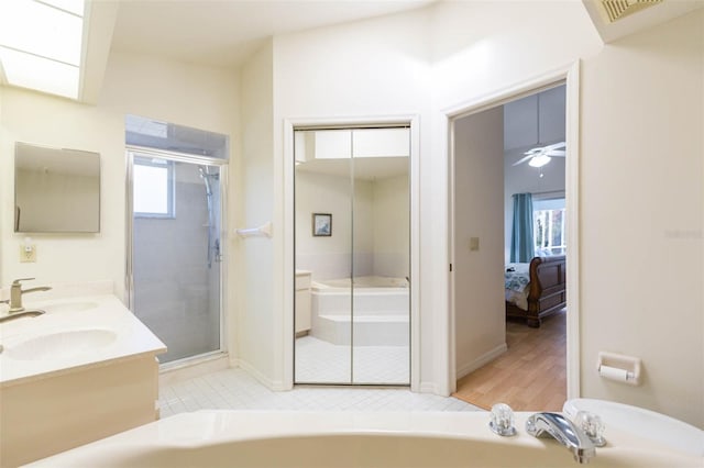 ensuite bathroom featuring a stall shower, a healthy amount of sunlight, and a bath