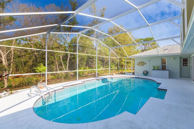 outdoor pool featuring glass enclosure and a patio area