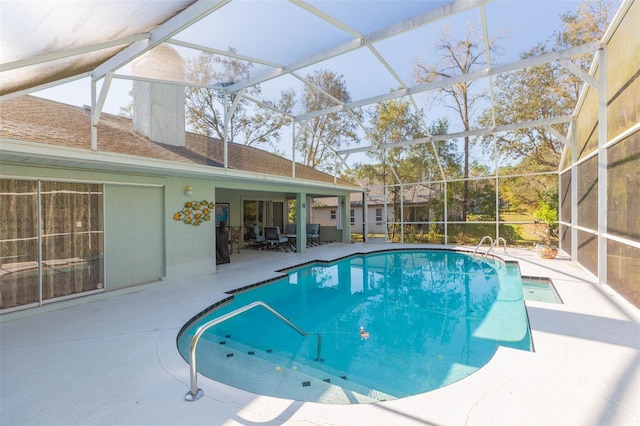 pool with glass enclosure and a patio