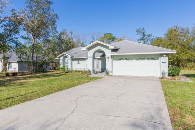 single story home with stucco siding, driveway, an attached garage, and a front yard