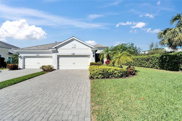 single story home featuring a garage, stucco siding, decorative driveway, and a front yard