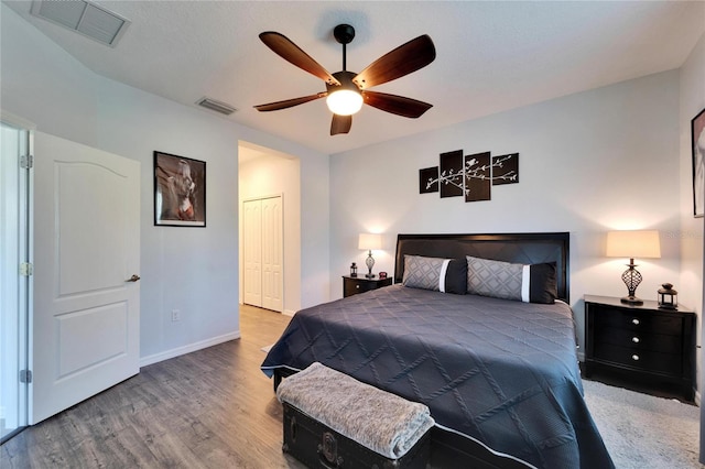 bedroom with visible vents, baseboards, wood finished floors, and a ceiling fan