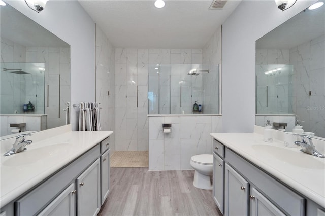 full bath with visible vents, toilet, wood finished floors, and vanity