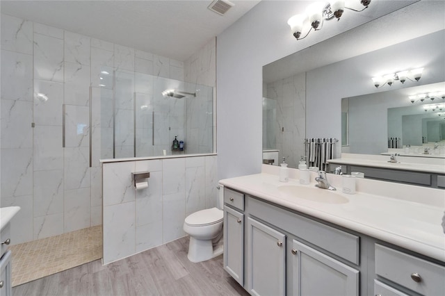 full bath featuring visible vents, walk in shower, toilet, wood finished floors, and vanity