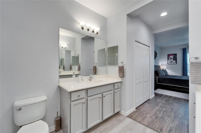 full bathroom with toilet, wood finished floors, ensuite bath, baseboards, and vanity