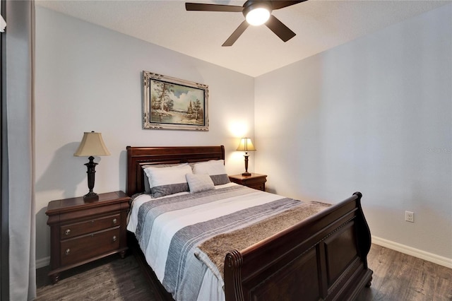 bedroom with dark wood finished floors, a ceiling fan, and baseboards