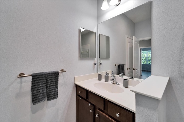 bathroom with vanity and a textured wall