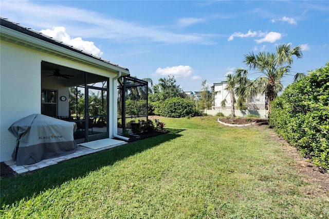 view of yard with a ceiling fan and a sunroom