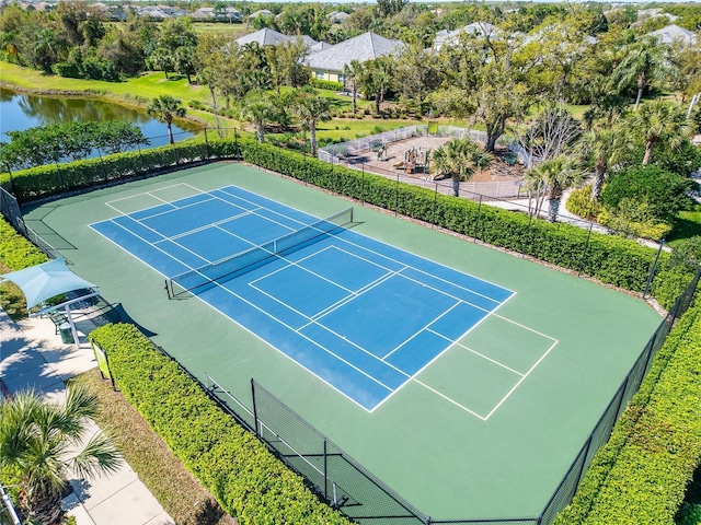 view of sport court with a water view and fence