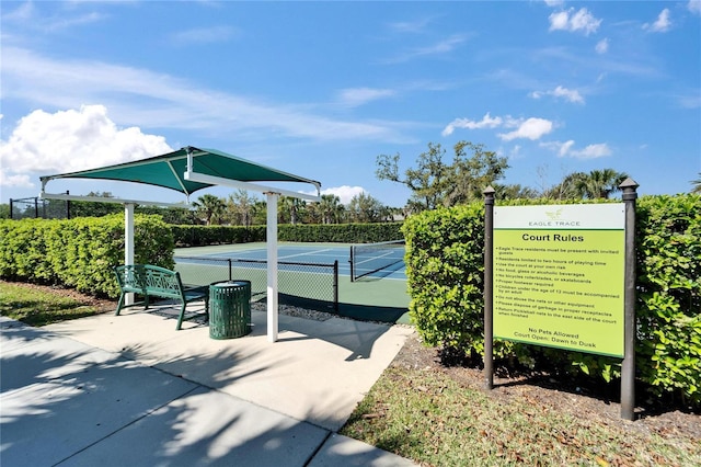 view of community featuring a tennis court and fence