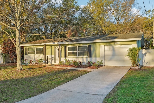 single story home featuring a garage, concrete driveway, and a front lawn