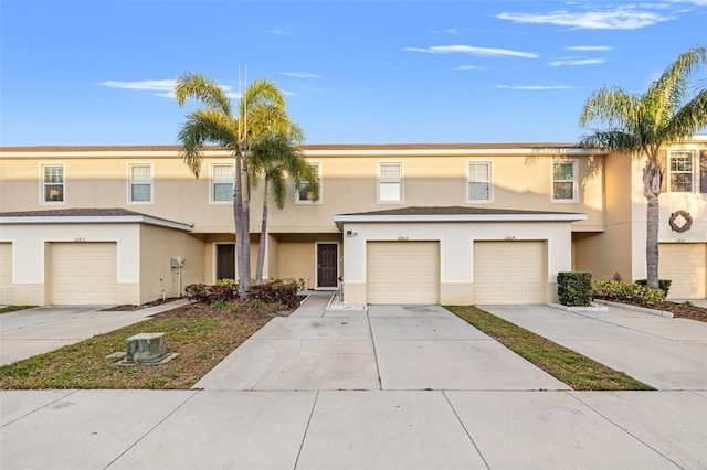 townhome / multi-family property featuring an attached garage, driveway, and stucco siding