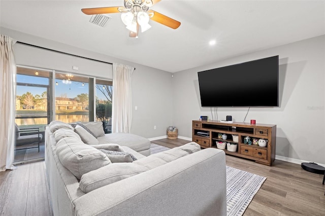 living room with a ceiling fan, visible vents, baseboards, recessed lighting, and light wood-type flooring