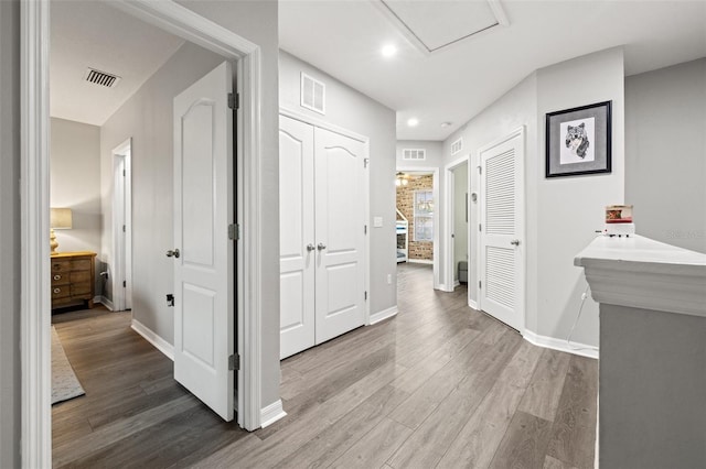 corridor with visible vents and wood finished floors