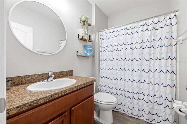 bathroom with toilet, vanity, a shower with curtain, and wood finished floors