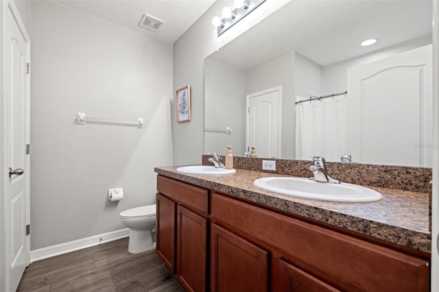 full bath with toilet, wood finished floors, visible vents, and a sink