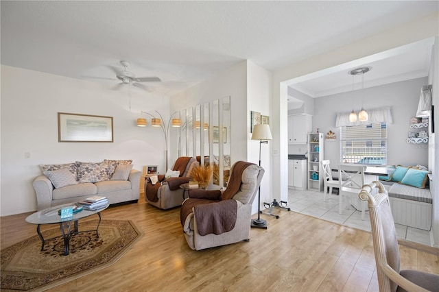 living area featuring light wood-type flooring and ceiling fan