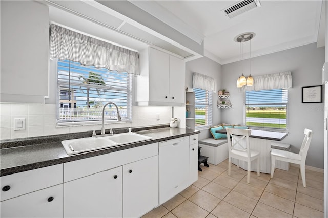 kitchen with a sink, dark countertops, white cabinetry, breakfast area, and white dishwasher