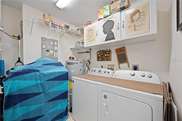 clothes washing area featuring washing machine and clothes dryer, laundry area, a textured ceiling, and electric water heater