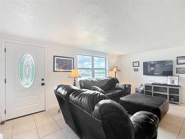 living area featuring light tile patterned floors, a textured ceiling, and baseboards