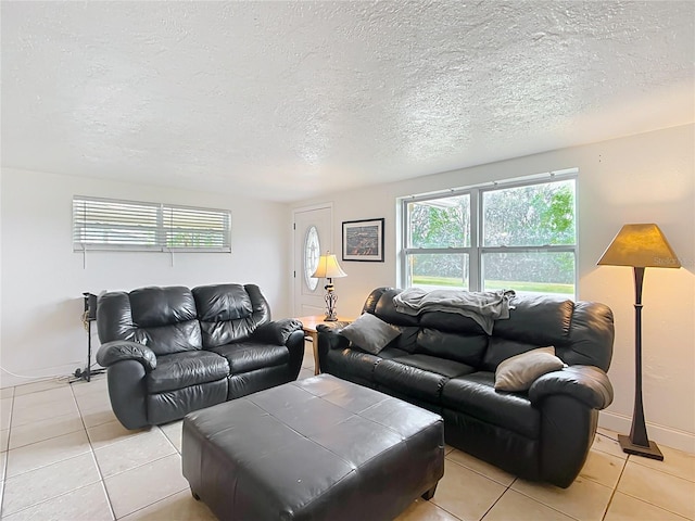 living room featuring light tile patterned floors, baseboards, and a textured ceiling