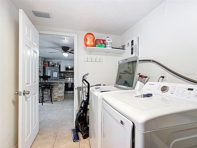 washroom featuring visible vents, a ceiling fan, washer and clothes dryer, light tile patterned floors, and laundry area