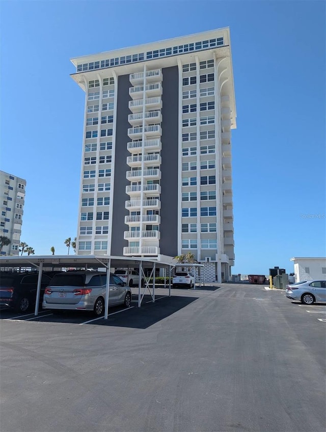 view of property featuring covered and uncovered parking