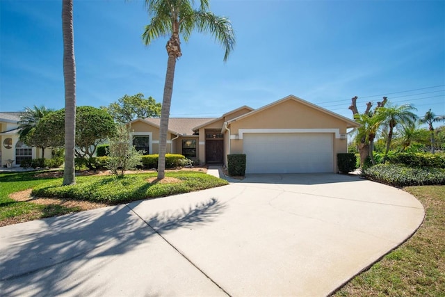 view of front of property with stucco siding, a garage, and driveway