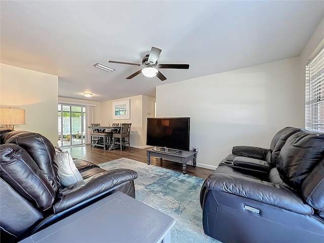 living area with visible vents, baseboards, ceiling fan, and wood finished floors