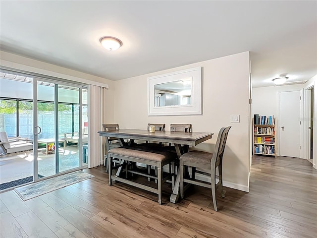 dining space featuring baseboards and wood finished floors