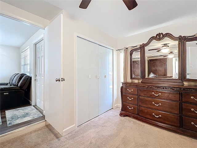 bedroom featuring light colored carpet, a closet, and ceiling fan