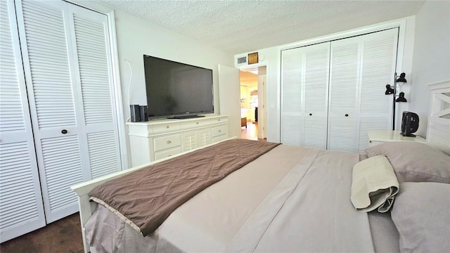 bedroom featuring two closets and a textured ceiling